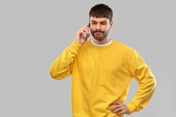 Puzzled young man calling on smartphone — Stok fotoğraf