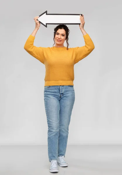 Happy young woman with big white thick left arrow — Stok fotoğraf