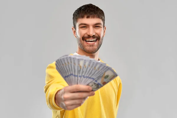 Jovem sorridente em camisola amarela com dinheiro — Fotografia de Stock