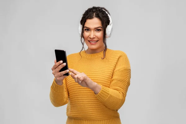 Femme dans les écouteurs avec smartphone — Photo