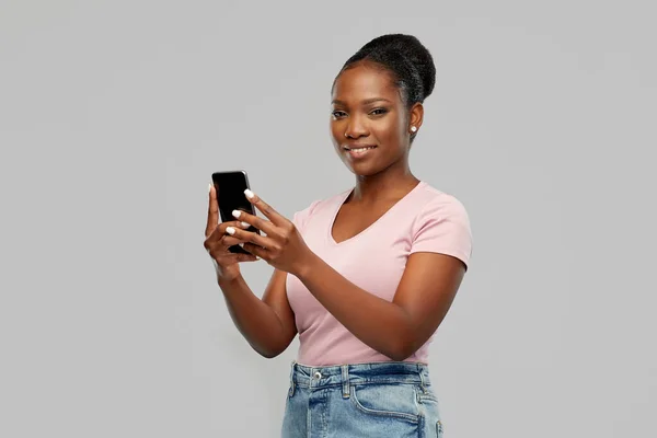 Heureuse femme afro-américaine en utilisant un smartphone — Photo