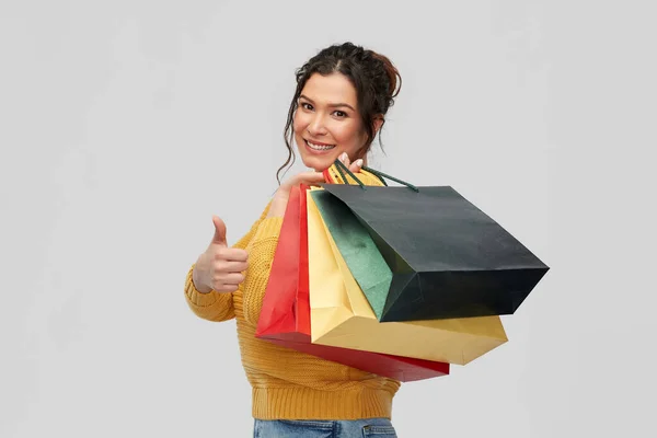 Alışveriş torbaları başparmak göstermek yukarıya ile gülümseyen kadın — Stok fotoğraf