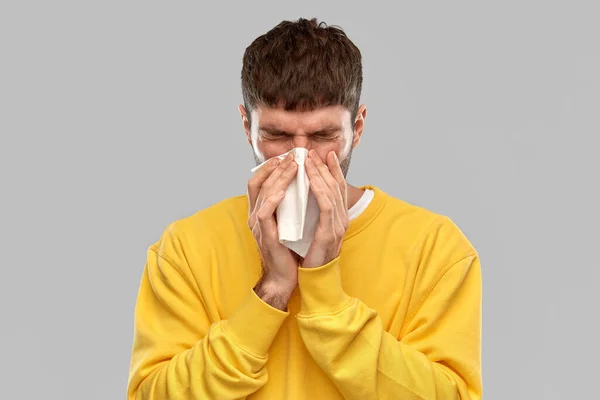 Hombre con servilleta de papel soplado nariz — Foto de Stock