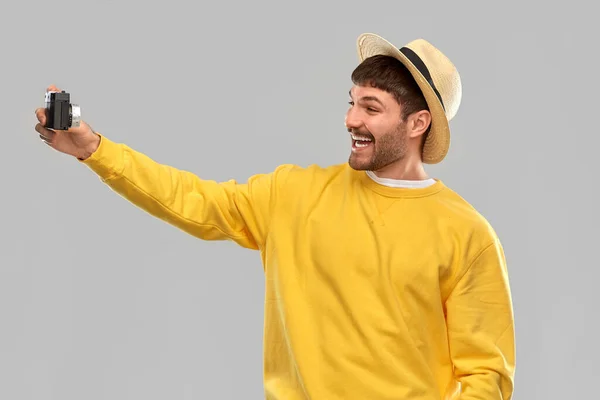 Щасливий чоловік у солом'яному капелюсі з старовинною плівковою камерою — стокове фото