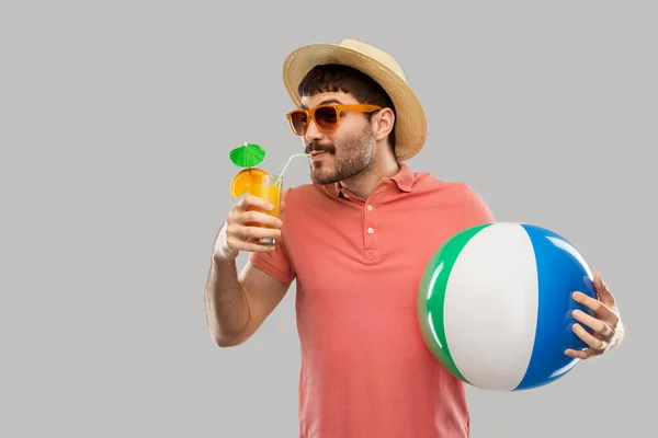 Щасливий чоловік з апельсиновим соком і пляжним м'ячем — стокове фото