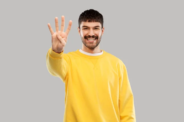 Άνδρας με κίτρινη μπλούζα που δείχνει τρία δάχτυλα — Φωτογραφία Αρχείου