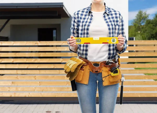 Mujer constructora con nivel y herramientas de trabajo en la correa —  Fotos de Stock