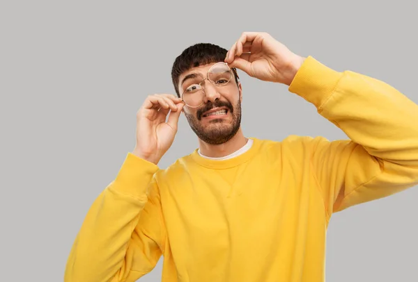 Doofer junger Mann mit Brille und gelbem Sweatshirt — Stockfoto