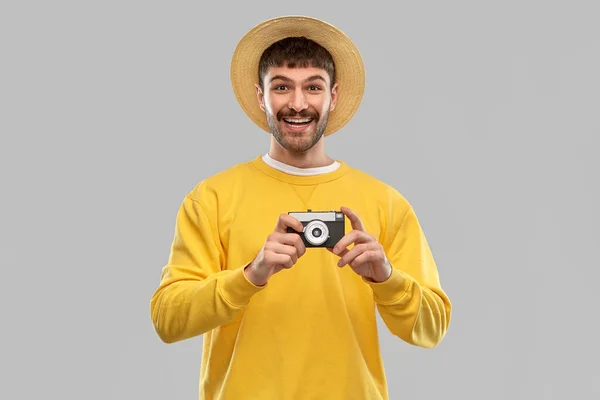Homem feliz em chapéu de palha com câmera de filme vintage — Fotografia de Stock