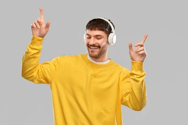 Happy smiling young man in headphones dancing — Stok fotoğraf