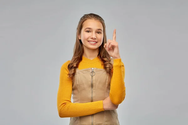 Sorridente giovane adolescente che punta il dito verso l'alto — Foto Stock