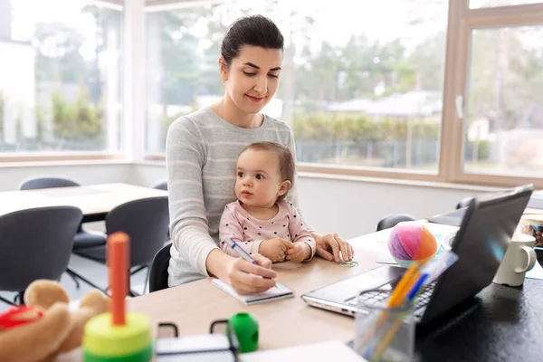 Madre con el bebé trabajando en casa oficina —  Fotos de Stock