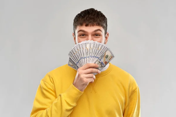 Happy young man in yellow sweatshirt with money — Φωτογραφία Αρχείου