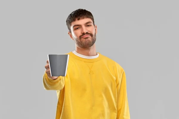 Displeased young man with coffee cup — Zdjęcie stockowe