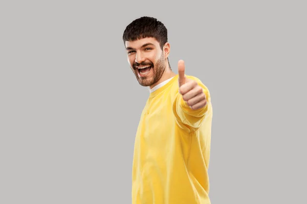 Sorrindo jovem mostrando polegares para cima — Fotografia de Stock