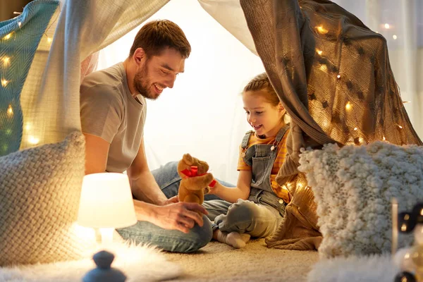 Famiglia felice che gioca con il giocattolo nella tenda dei bambini a casa — Foto Stock