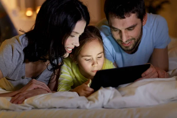 Rodziny z komputera typu tablet w łóżku w nocy w domu — Zdjęcie stockowe