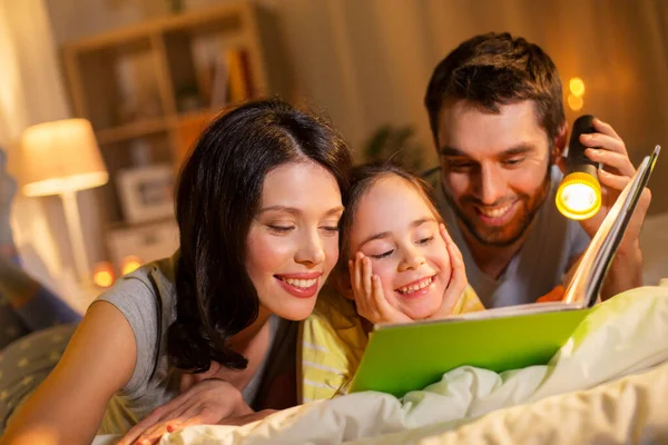 Libro de lectura familiar feliz en la cama por la noche en casa — Foto de Stock