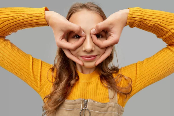 Tonårstjej som tittar genom fingerglasögon — Stockfoto