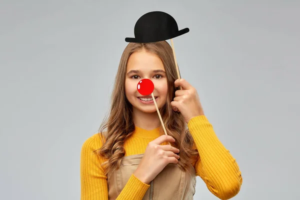 Smiling teenage girl with red clown nose and hat — Stockfoto