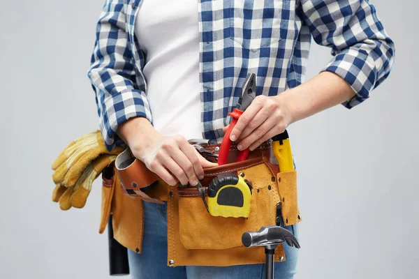 Mulher ou construtor com ferramentas de trabalho na correia — Fotografia de Stock