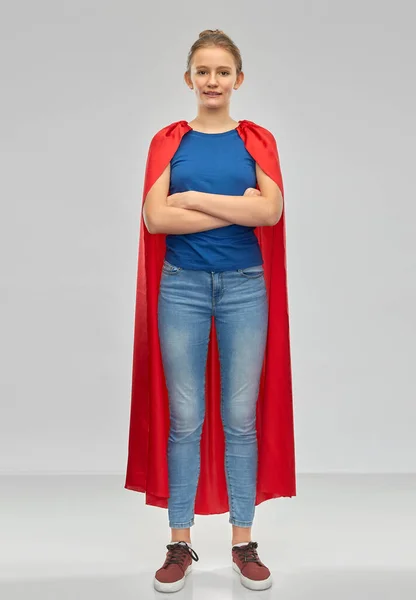 Uśmiechnięta nastolatka w czerwonej pelerynie superbohatera — Zdjęcie stockowe