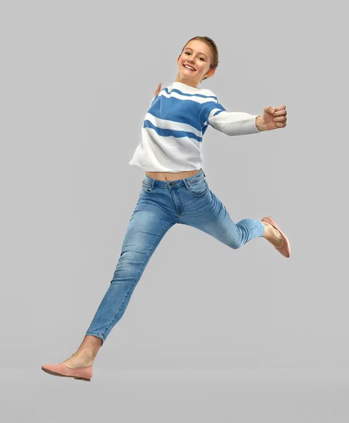 Smiling teenage girl in pullover jumping — Stock Photo, Image