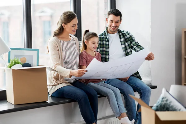 Happy family with blueprint moving to new home — Stock Photo, Image