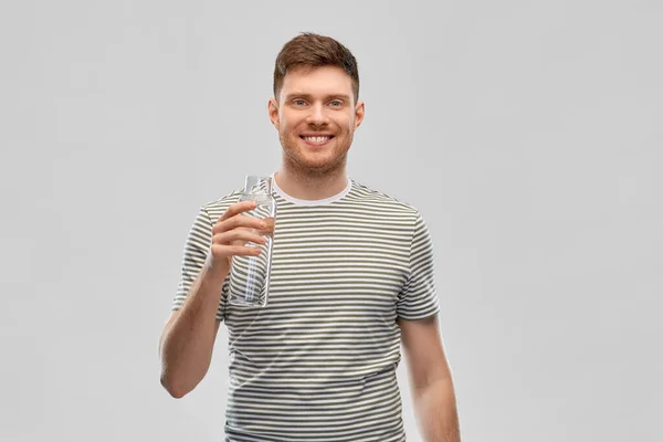 Felice uomo sorridente che tiene l'acqua in bottiglia di vetro — Foto Stock