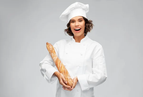 Felice chef donna con pane francese o baguette — Foto Stock