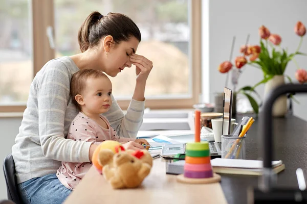Tired mother with baby working at home office — Stock Photo, Image