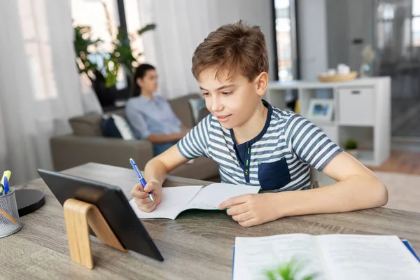 Student pojke med surfplatta datorinlärning hemma — Stockfoto