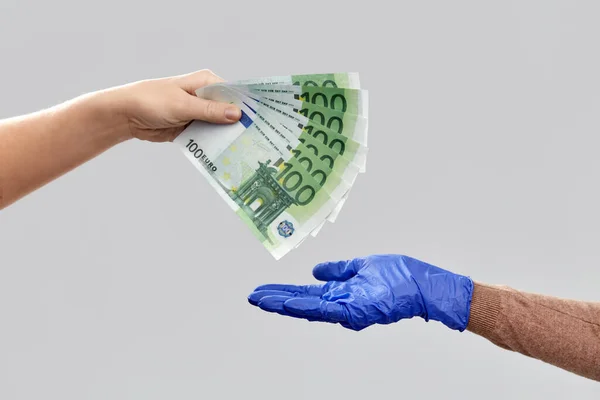 Primer plano de la mano en guante médico dando dinero — Foto de Stock