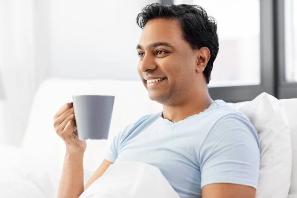 快乐的印度人在家里的床上喝咖啡 — 图库照片