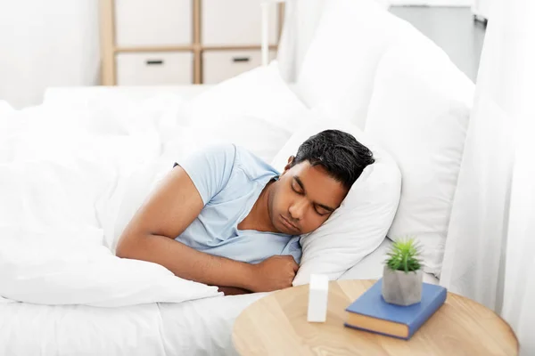 Индийский мужчина спит в постели дома — стоковое фото