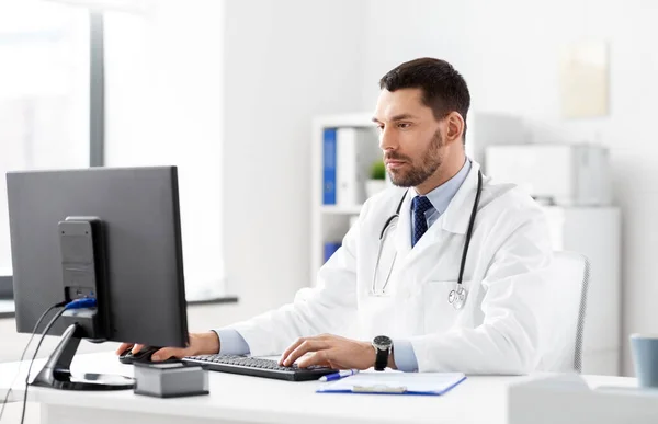 Male doctor with computer working at hospital — Stock Photo, Image