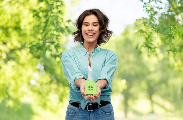 Χαμογελαστή νεαρή γυναίκα κρατώντας πράσινο σπίτι — Φωτογραφία Αρχείου