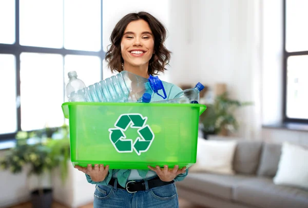 Sonriente joven mujer clasificación de residuos de plástico — Foto de Stock