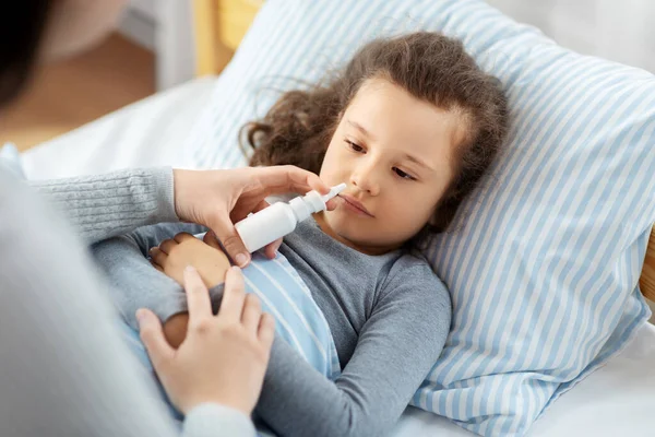 Mor med nässpray behandlar sjuk dotter — Stockfoto