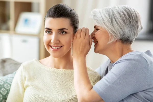 Senior moeder fluistert geheim aan volwassen dochter — Stockfoto