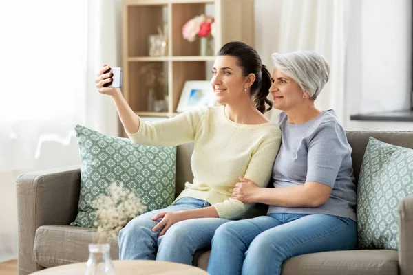 Ηλικιωμένη μητέρα με κόρη που βγάζει selfie στο σπίτι — Φωτογραφία Αρχείου