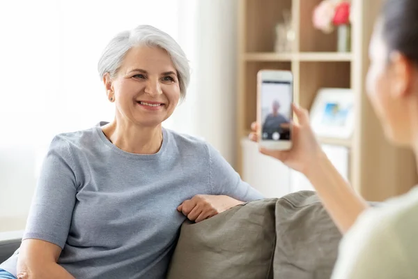 Hija adulta fotografiando a la madre mayor en casa — Foto de Stock