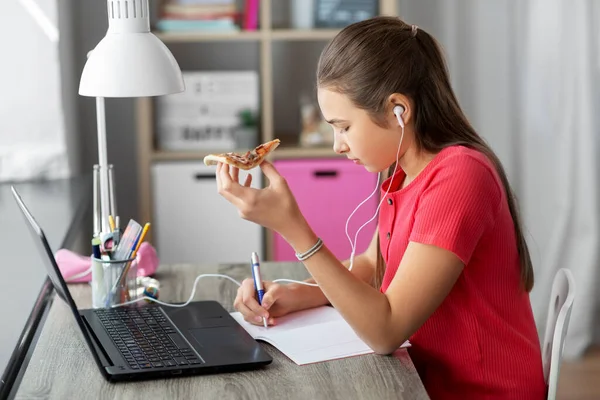 Studentka w słuchawkach z pizzą w domu — Zdjęcie stockowe