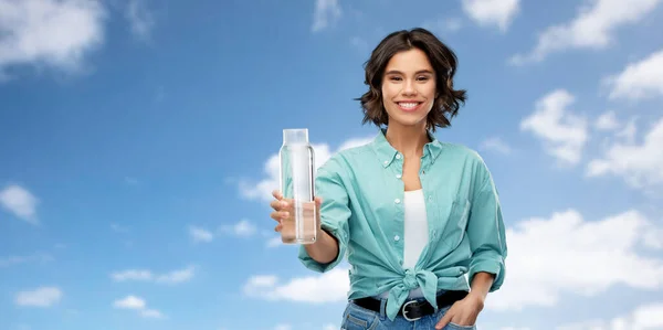 Χαμογελαστή νεαρή γυναίκα κρατώντας το νερό σε γυάλινο μπουκάλι — Φωτογραφία Αρχείου