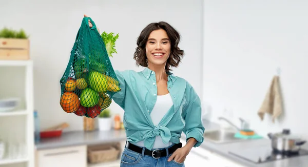 Mujer sonriente feliz con comida en bolsa de red reutilizable —  Fotos de Stock