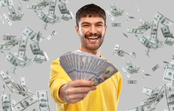 Lächelnder junger Mann im gelben Sweatshirt mit Geld — Stockfoto