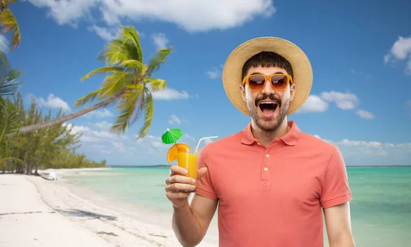 Uomo felice in cappello di paglia con succo di frutta sulla spiaggia — Foto Stock