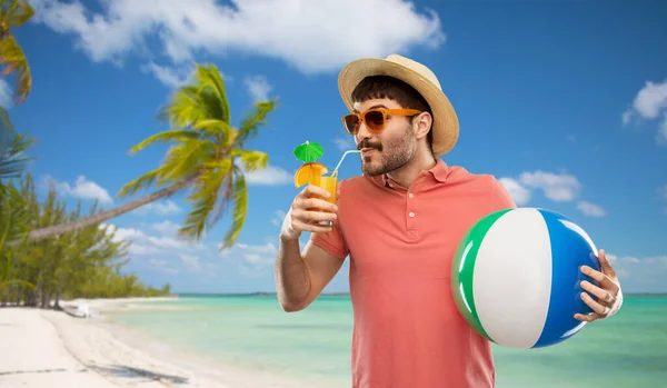 Uomo felice in cappello di paglia con succo di frutta sulla spiaggia — Foto Stock