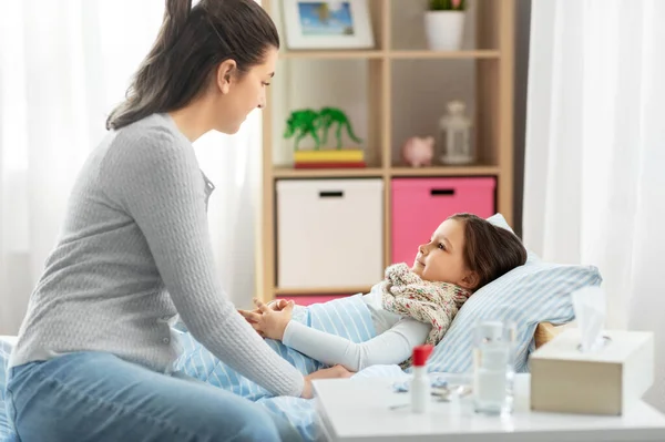 Mutter und kranke kleine Tochter zu Hause im Bett — Stockfoto