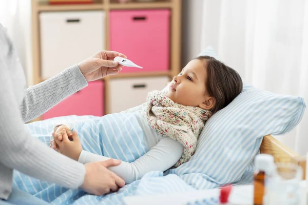 Mother measuring temperature of sick daughter — Stock Photo, Image